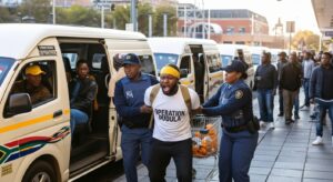 A Operation Dudula 'Thug' Busted and arrested at MTN Johannesburg for demanding passports and R2,000 fines from suspected illegal immigrants. Details on the Jeppe Police Station bust and Home Affairs response.